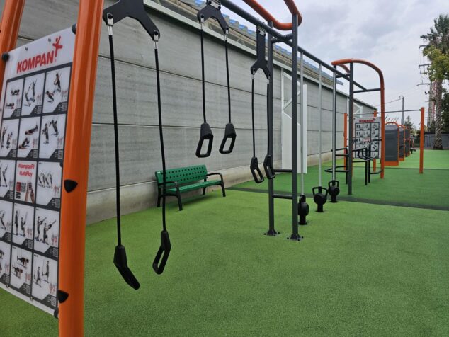 Imagen: Fotografía del gimnasio exterior municipal de Calp con equipamiento deportivo Kompan sobre césped artificial.