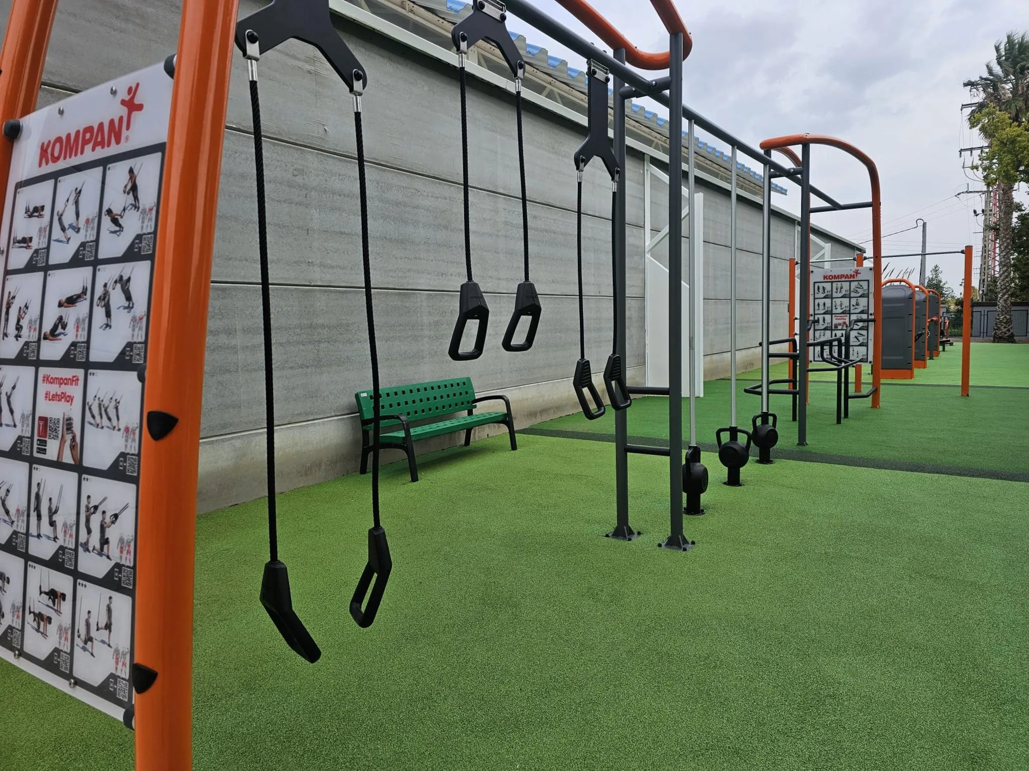 Fotografía del gimnasio exterior municipal de Calp con equipamiento deportivo Kompan sobre césped artificial.