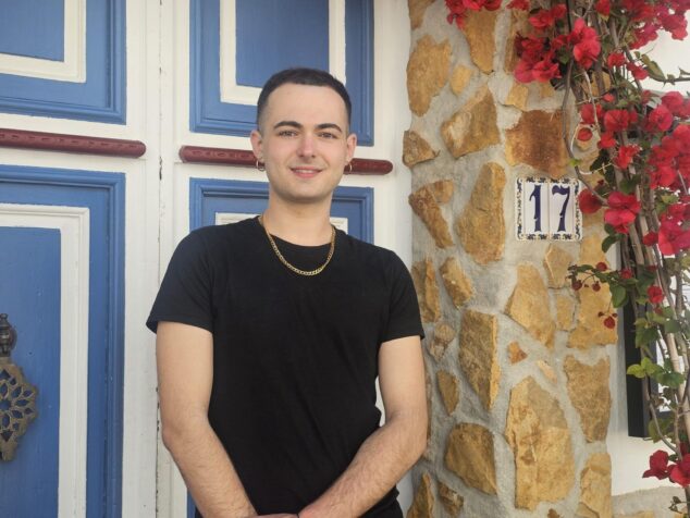 Imagen: Retrato de Lluís Tur, pregonero del CalPride 2026, sonriendo ante una puerta tradicional.