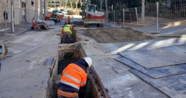 Trabajadores en una zanja instalando tuberías para el nuevo colector de pluviales en una calle de Calp.