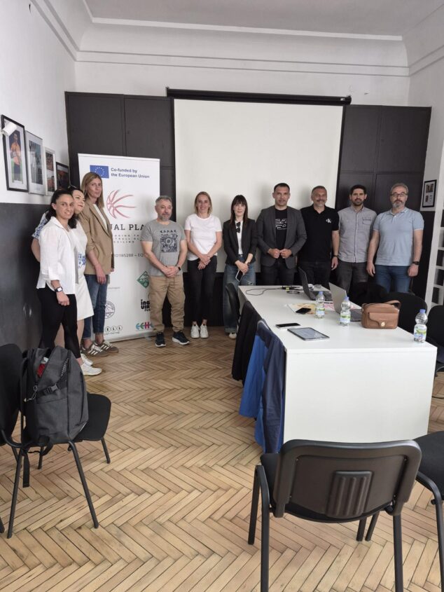 Un grupo de unas diez personas posa de pie en una sala de reuniones delante de un cartel del proyecto europeo EQUALPLAY.