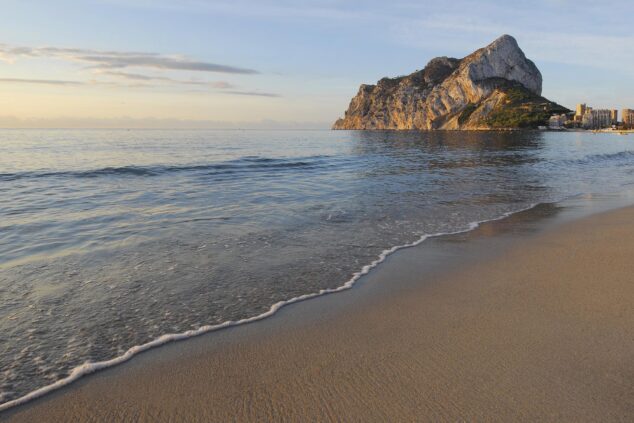 Imagen: Playa de la Fossa en Calp con el Peñón de Ifach al fondo al atardecer.