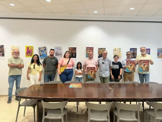 Pedreguer elige «Fent Banda per Bou» de Vicente Costa como cartel de sus Festes de Juliol 2026 3 Imagen: Foto de grupo de personas sosteniendo el cartel ganador de las fiestas de Pedreguer 2026.