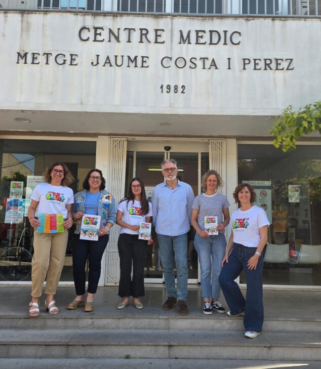 Imagen: Grupo de personas posando frente al Centro Médico de Pedreguer con carteles de la I Fira de la Salut.