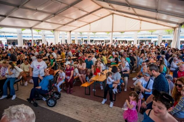 Multitud de personas sentadas en mesas bajo una gran carpa durante la feria FiraCalp.