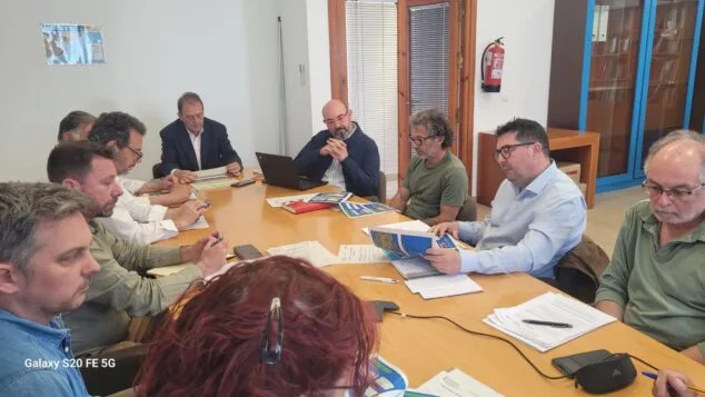 Imagen: Varios hombres sentados alrededor de una mesa de reuniones revisando documentos durante la Junta Rectora del Penyal d'Ifach.