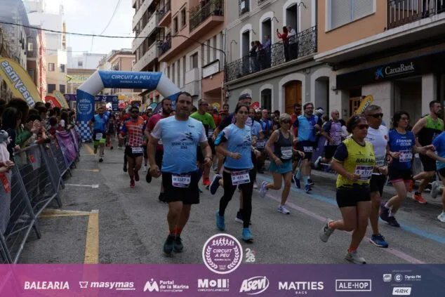 Kiket Roselló y Eri Yonamine se coronan en la XXXIII Cursa Popular Vila de Pedreguer 6 Imagen: Salida de la Cursa Popular de Pedreguer con cientos de corredores bajo un arco inflable.