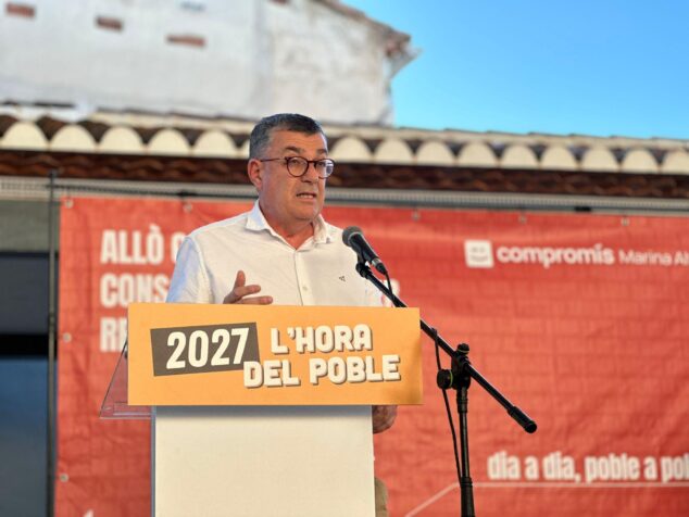 Compromís conmemora 15 años en la alcaldía de Pedreguer y activa su precampaña para 2027 3 Imagen: Enric Morera hablando en un atril con el lema '2027 L'HORA DEL POBLE'.