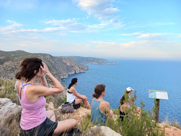 «Respira l’estiu», las meditaciones guiadas de Benitatxell, vuelven para un verano de bienestar consciente 1 Imagen: Grupo de personas sentadas en un acantilado mirando al mar durante una sesión del ciclo 'Respira l'estiu' en Benitatxell.