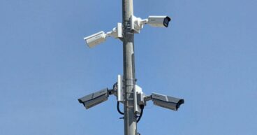 Un poste metálico con varias cámaras de videovigilancia instaladas en Calp bajo un cielo azul.