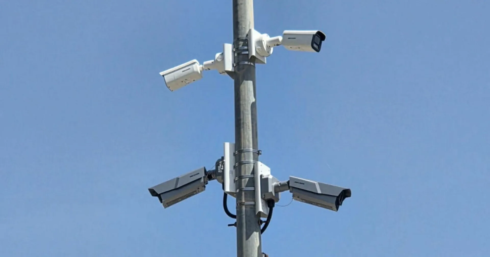 Un poste metálico con varias cámaras de videovigilancia instaladas en Calp bajo un cielo azul.