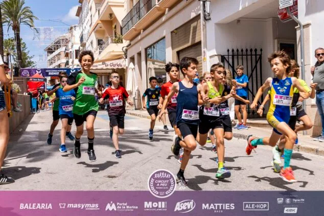 Imagen: Grupo de niños corriendo por una calle durante la carrera infantil de la XXVII Cursa Popular Benissa.