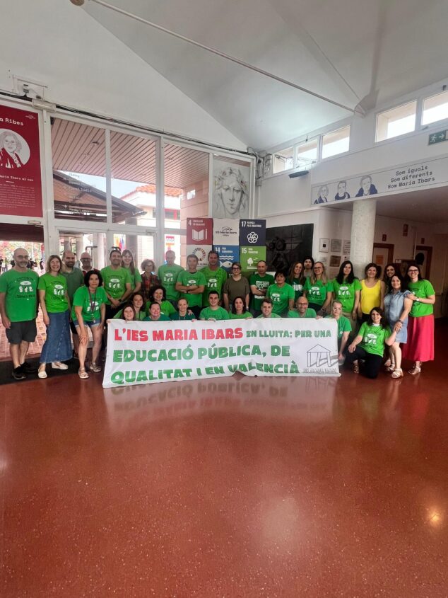 La comunidad educativa de la Marina Alta se moviliza en plena negociación con Conselleria por la inclusión 13 Un grupo numeroso de docentes y personal del IES Maria Ibars de Dénia posa en el vestíbulo del instituto sosteniendo una gran pancarta que dice "L'IES MARIA IBARS EN LLUITA: PER UNA EDUCACIÓ PÚBLICA, DE QUALITAT I EN VALENCIÀ". La mayoría viste camisetas verdes con el lema "Estimem l'escola pública".