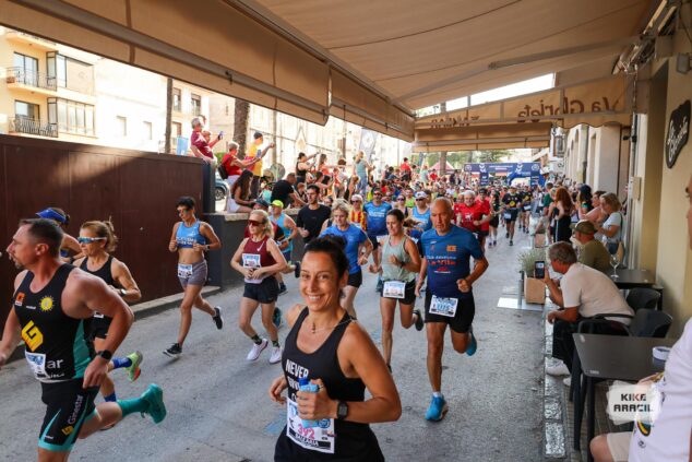Imagen: Grupo de corredores participando en una carrera popular por una calle urbana.