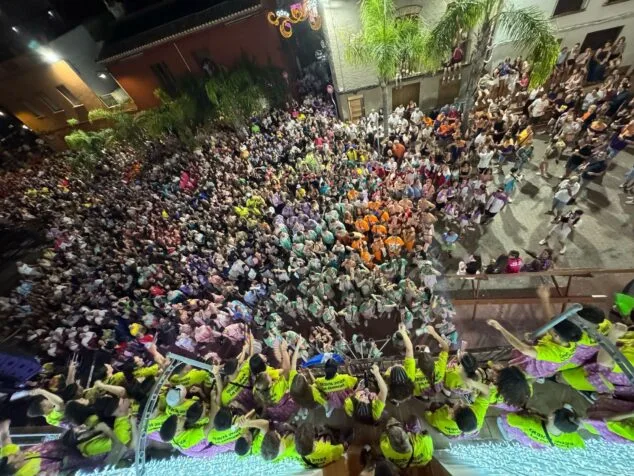 Fotografía de una multitud de personas celebrando en una plaza durante la noche en Ondara