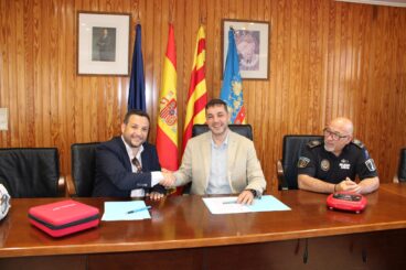 José Ramiro, alcalde de Ondara, estrecha la mano a Juan David Gómez, director de HCB, ante Toni Galiano, jefe de Policía Local, tras firmar un convenio.