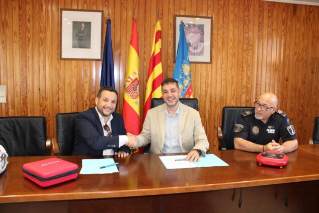Imagen: José Ramiro, alcalde de Ondara, estrecha la mano a Juan David Gómez, director de HCB, ante Toni Galiano, jefe de Policía Local, tras firmar un convenio.