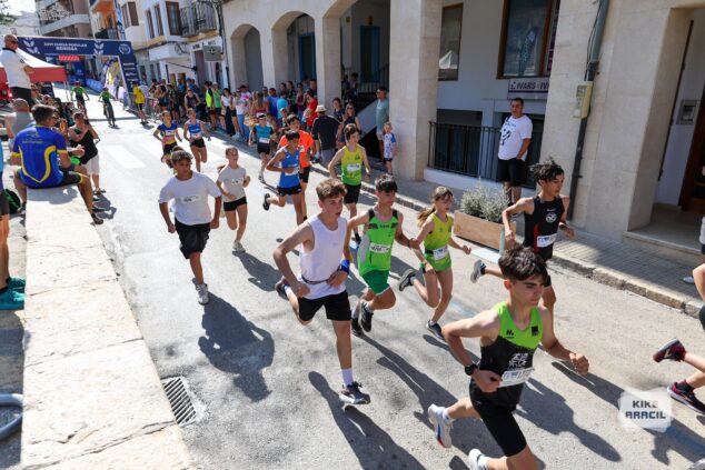 Imagen: Grupo de niños y adolescentes corriendo en una carrera urbana en Benissa con dorsales.