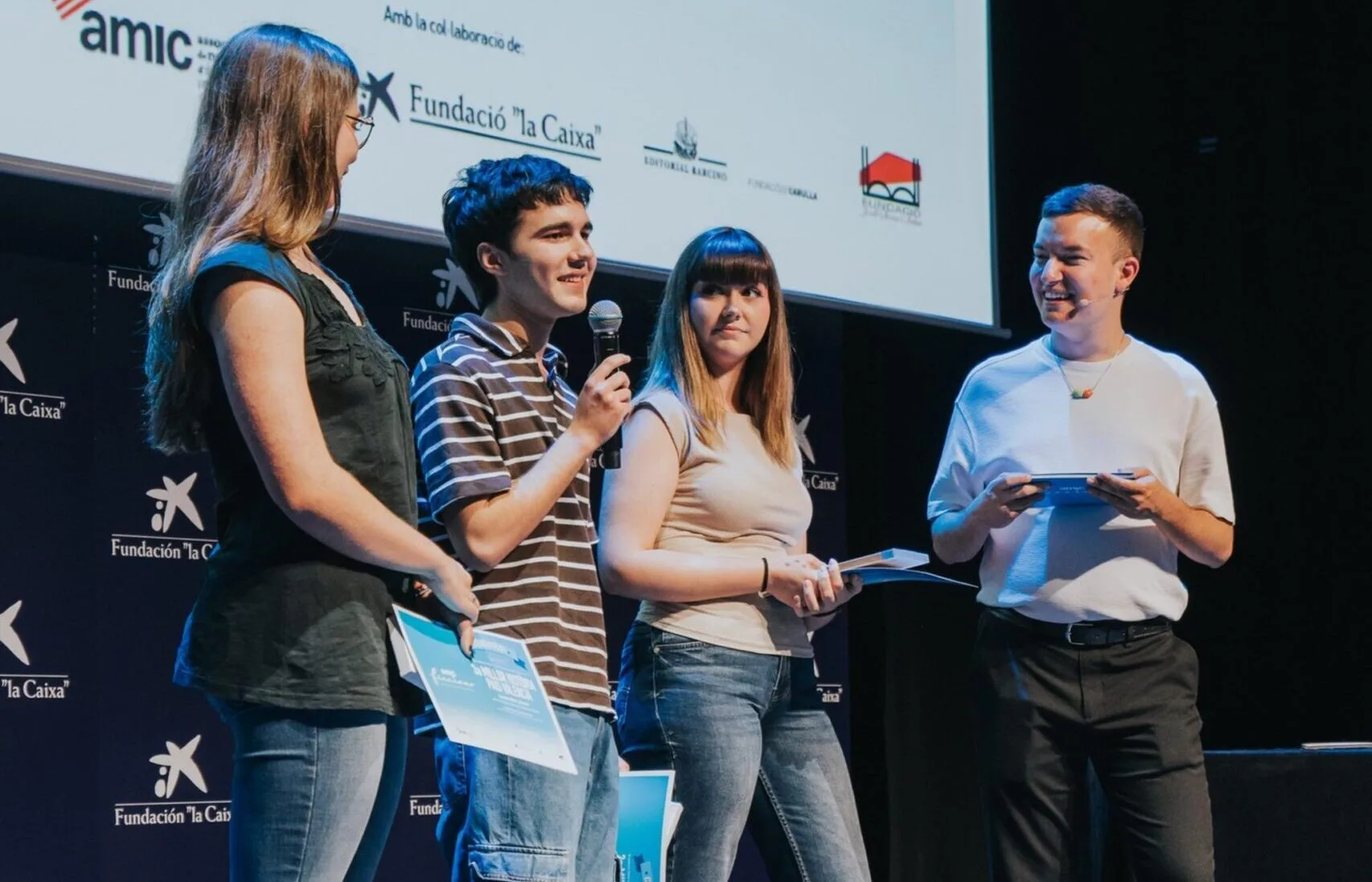 Martí Jorro Batalla y otros jóvenes reciben premios en el escenario durante el concurso AMIC-Ficcions.
