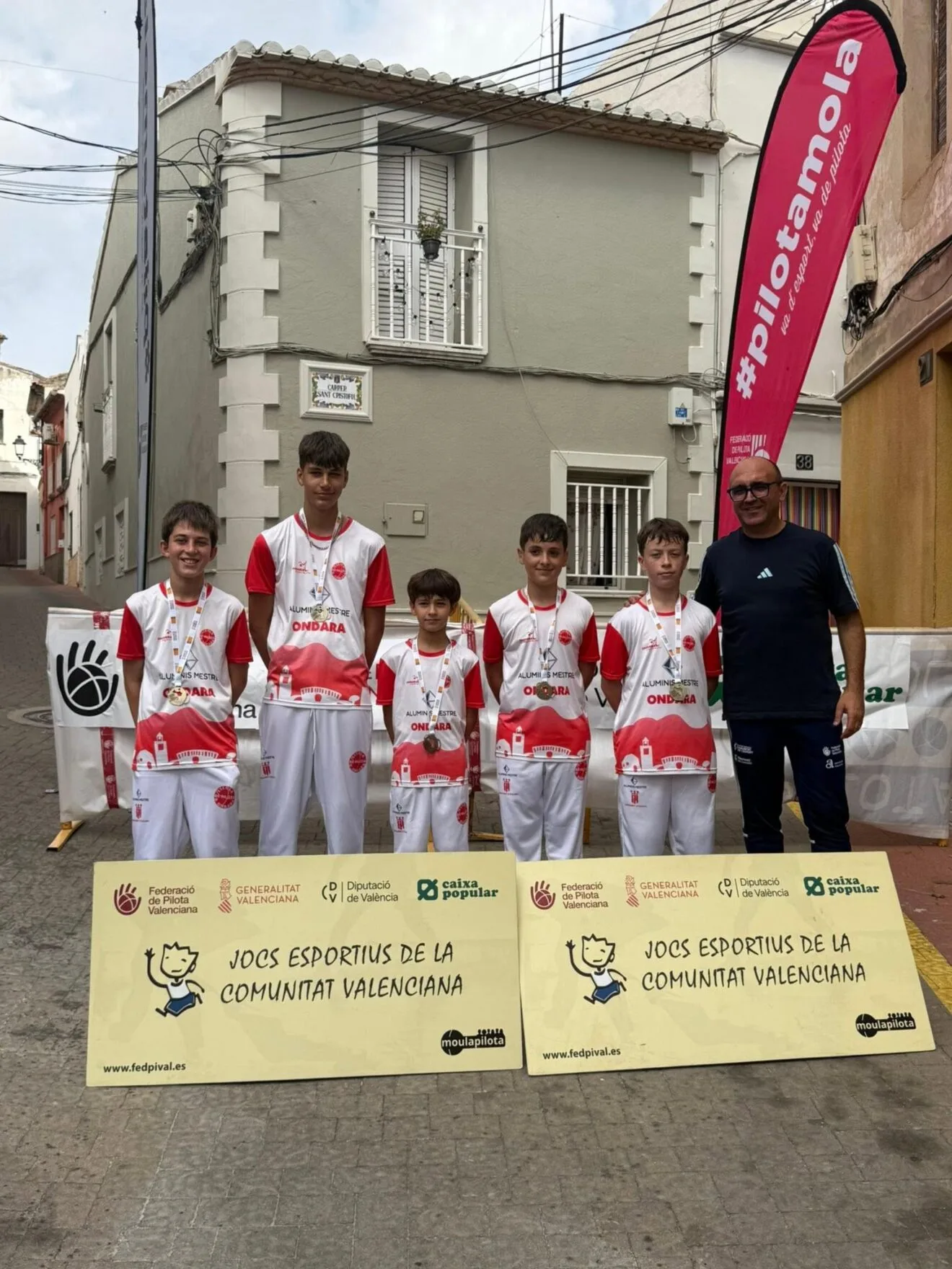 Players and coach of the Ondara Pilota School with medals from the JECV finals.