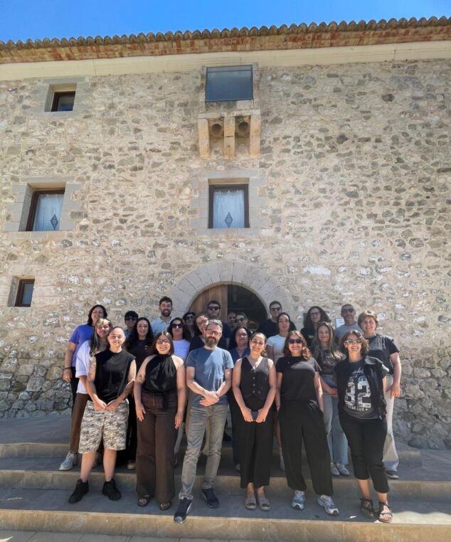 La Xarxa Jove de la Marina Alta forma a profesionales en Calp 1 Imagen: Grup de persones participants en un curs de formació davant d'un edifici de pedra a Calp.