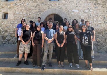 Grup de persones participants en un curs de formació davant d'un edifici de pedra a Calp.
