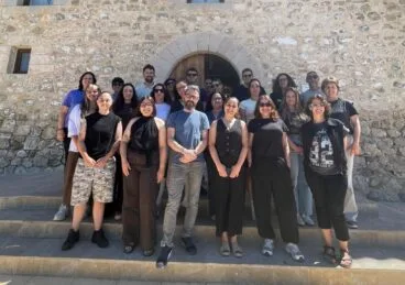 La Xarxa Jove de la Marina Alta forma a profesionales en Calp 22 Grup de persones participants en un curs de formació davant d'un edifici de pedra a Calp.
