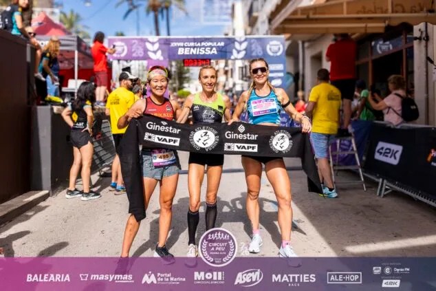 Imagen: María Isabel Ferrer, Eri Yonamine y Cristina Roselló posan en el podio de ganadoras de la XXVII Cursa Popular Benissa.
