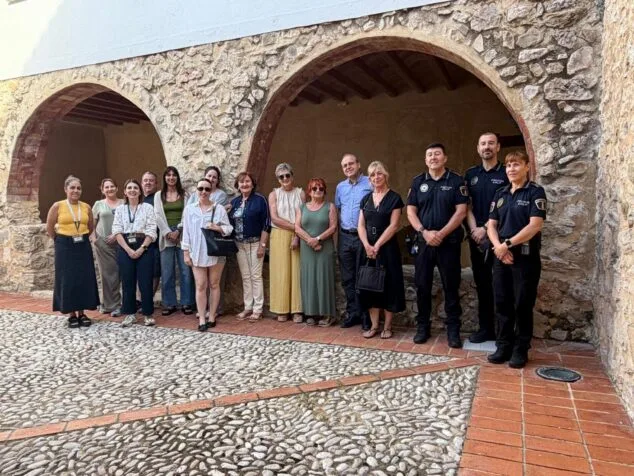 Grupo de personas y policías locales de Calp posando en un patio durante la presentación de la red de ocio seguro.
