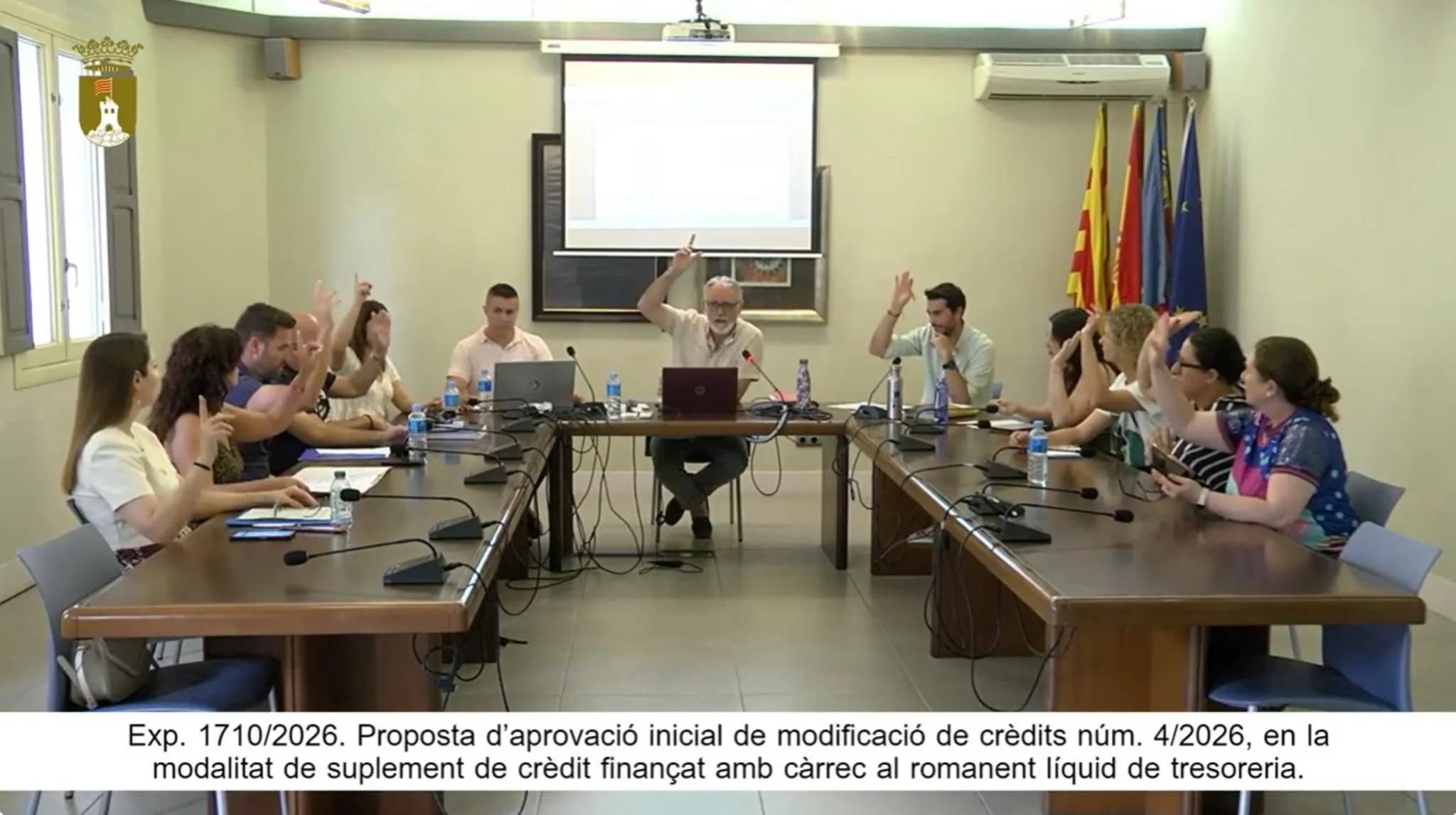 Varios concejales levantan la mano para votar durante una sesión plenaria en el Ayuntamiento de Pedreguer.