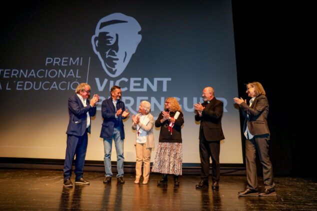 La Asociación Vicent Berenguer eleva a 36.000 euros su premio a proyectos educativos 1 Imagen: Seis personas aplauden en un escenario con una gran pantalla detrás que anuncia el Premi Internacional a l’Educació Vicent Berenguer.