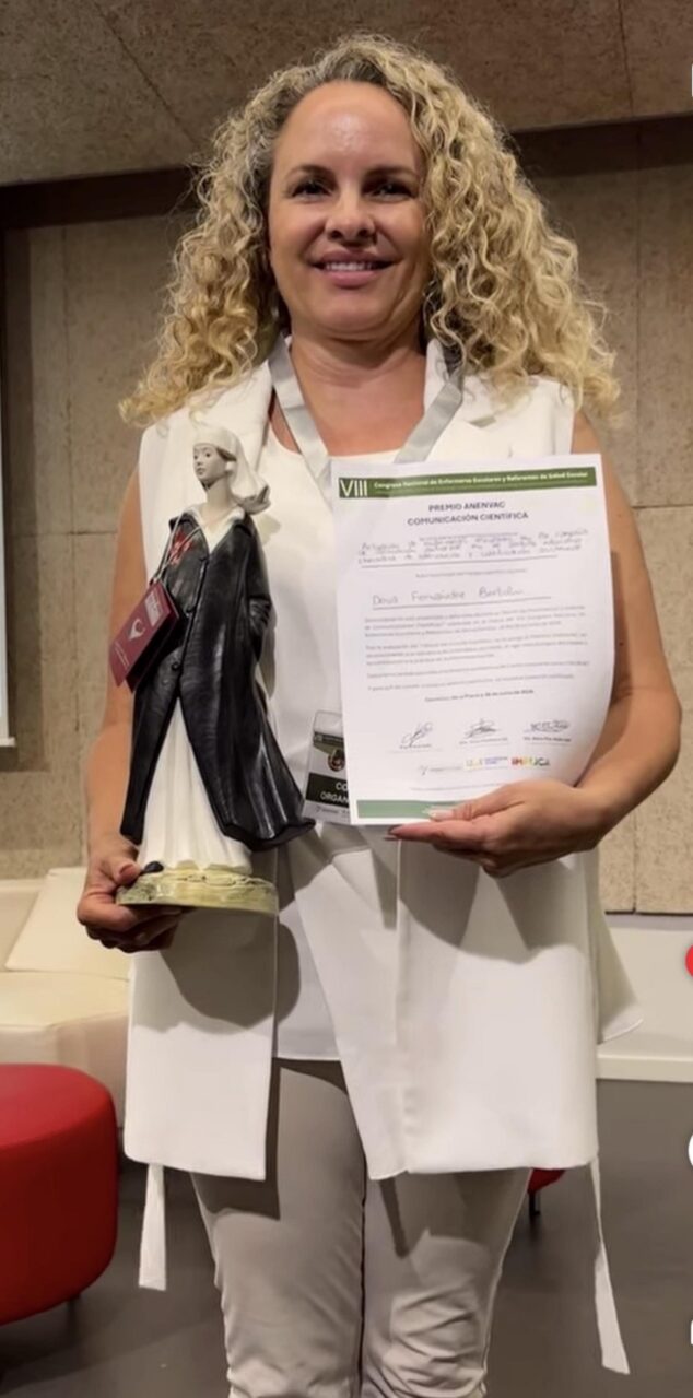 Imagen: Deva Fernández Bertolini sosteniendo un trofeo y un diploma de premio