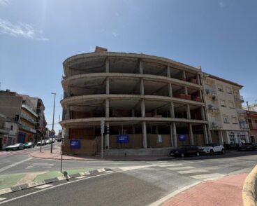 Estructura de hormigón de un edificio inacabado en una esquina de una calle en Benitatxell.