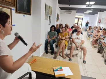 Elvira Cambrils hablando con un micrófono durante la presentación de su libro 'Gramática de los girasoles' frente a un público sentado.