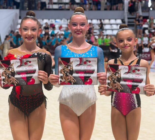 Sophie O'Reilly, del Club Les Marines de Calp, Campeona de España de gimnasia rítmica en pelota 2 Imagen: Tres gimnastas del Club Les Marines sostienen diplomas en el interior de un pabellón deportivo tras el Campeonato de España.