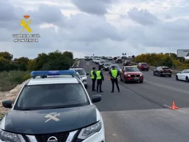 Agentes y vehículo de la Guardia Civil en un control de carretera.
