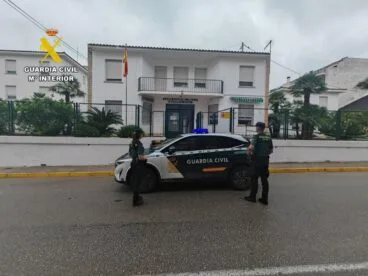 Agentes y vehículo patrulla de la Guardia Civil frente al cuartel de Pego.