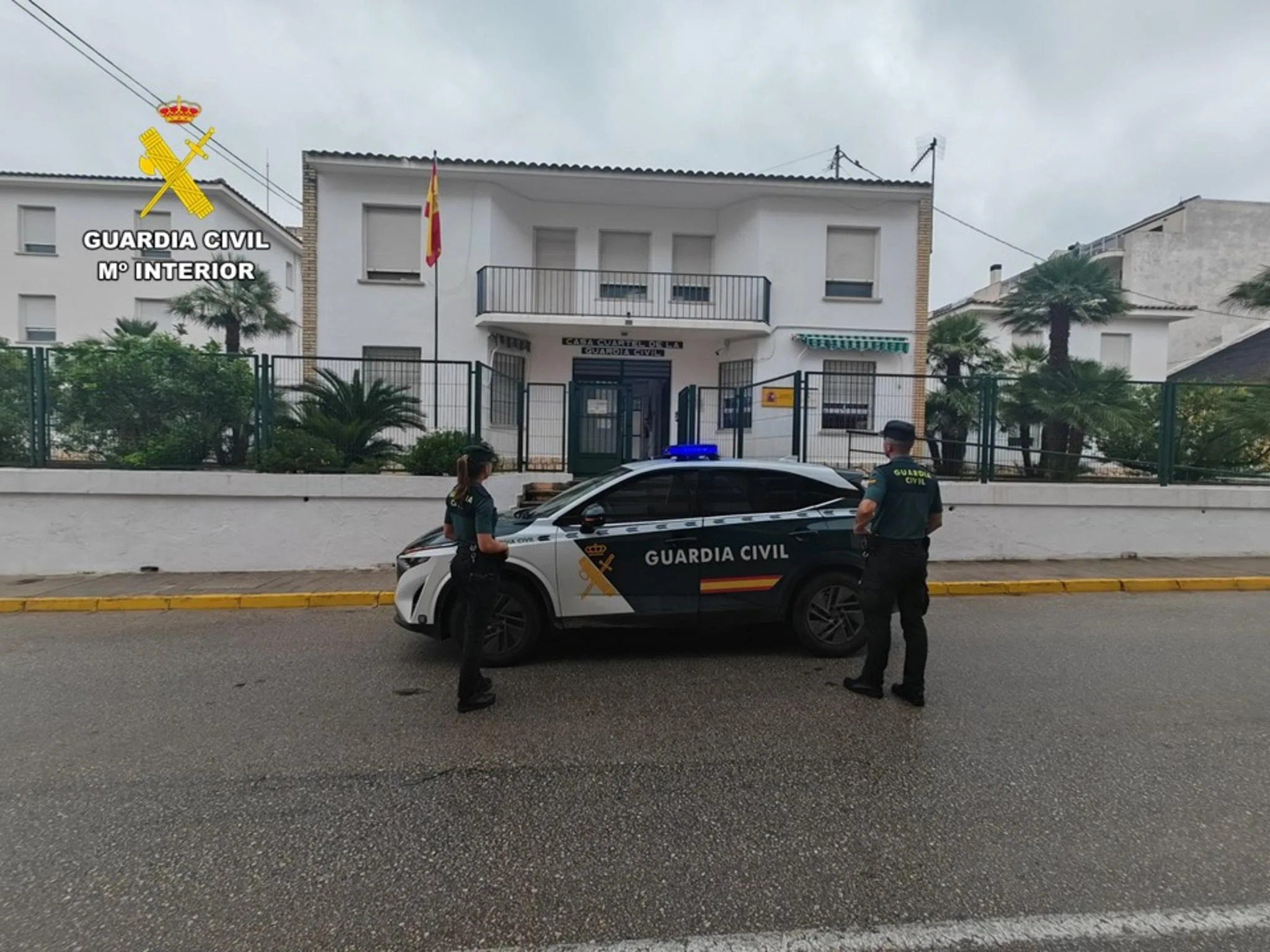 Agentes y vehículo patrulla de la Guardia Civil frente al cuartel de Pego.