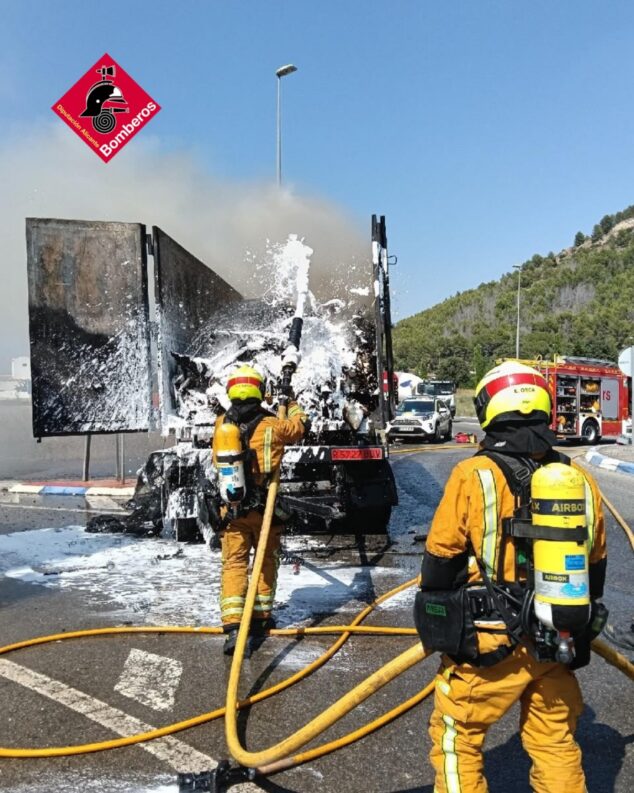 Imagen: Bomberos extinguen con espuma el incendio de la carga de un camión en una carretera.
