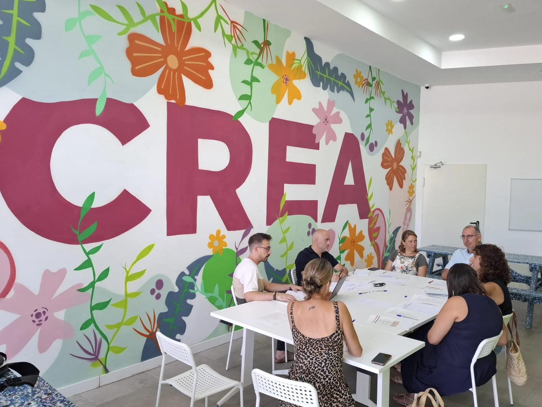 Varios profesionales sentados alrededor de una mesa blanca durante una reunión de trabajo del proyecto ChildStory.