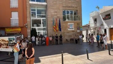 Personas guardando un minuto de silencio frente al edificio del Ayuntamiento de Calp