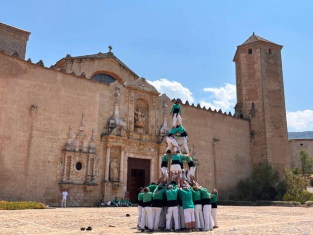 La Muixeranga de la Marina Alta protagoniza un histórico homenaje a Jaume I en el Monasterio de Poblet 5 Imagen: Miembros de la Muixeranga de la Marina Alta formando una torre humana frente a la fachada de piedra del Monasterio de Poblet.