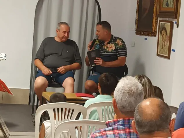 Imagen: Joan Mestre y Jovi Lozano-Seser sentados en un escenario durante la presentación del libro 'Gala balsámica' en Ondara.