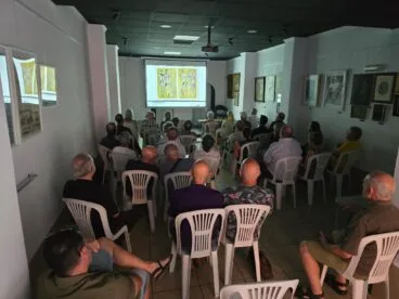 Público sentado en una sala viendo la proyección de un documental sobre el artista Joan Castejón.