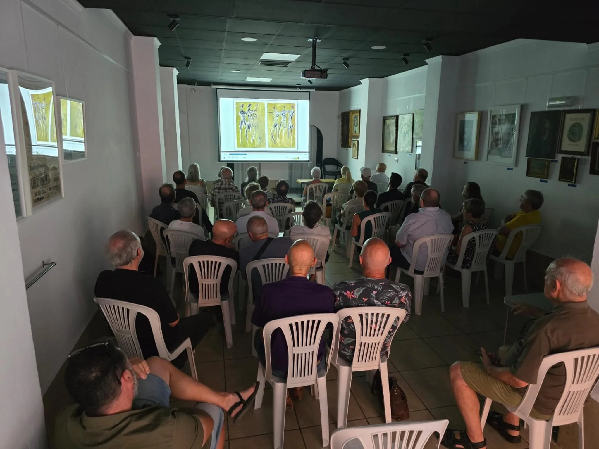 Público sentado en una sala viendo la proyección de un documental sobre el artista Joan Castejón.