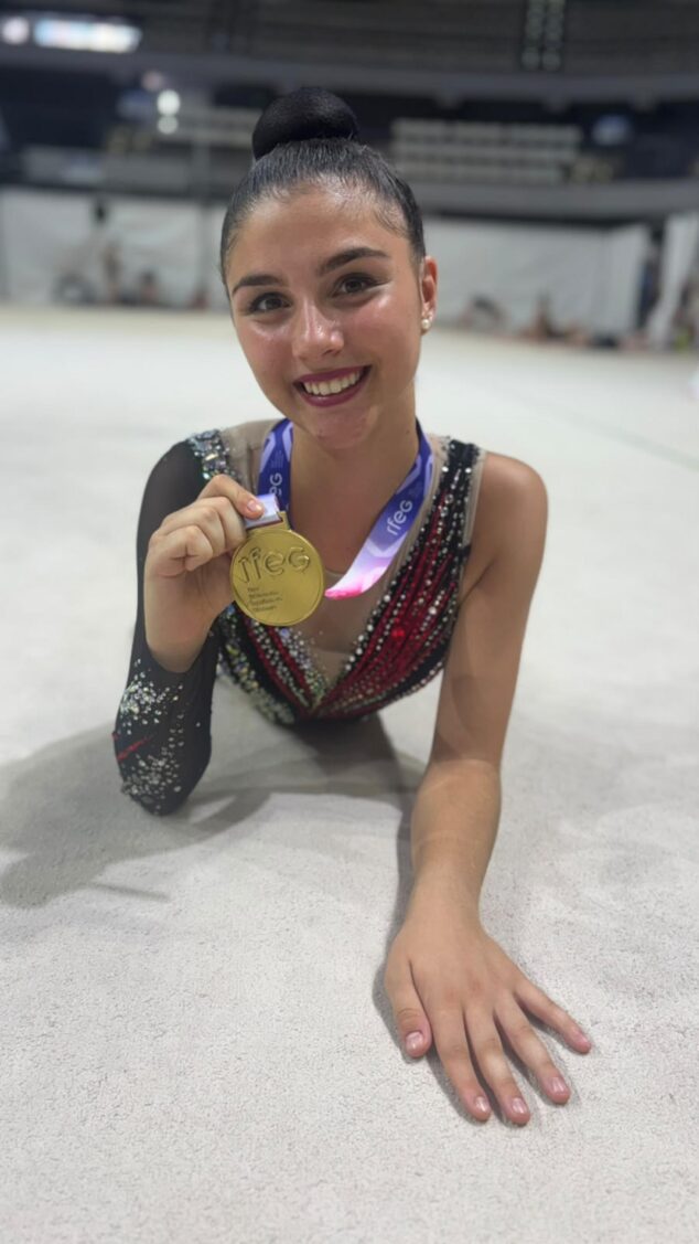 El CG Calpe logra cuatro títulos nacionales en el Campeonato de España por Equipos 2 Imagen: Fotografía de la gimnasta Stella Galstyan tumbada en el suelo sonriendo y mostrando a cámara una medalla de oro.