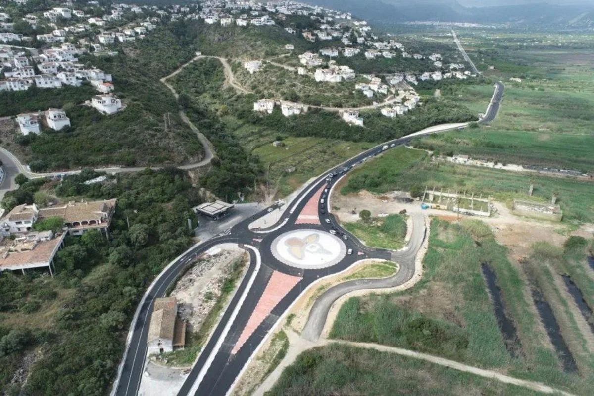 Vista aérea de una nueva rotonda de acceso a la urbanización Monte Pego con casas en la ladera.