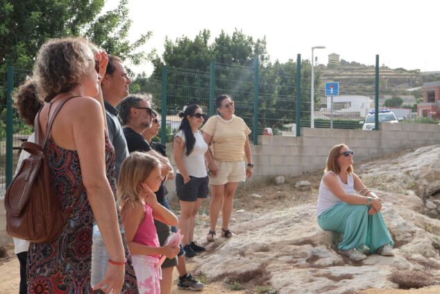 Imagen: Asistentes a la jornada de puertas abiertas en la Cova de les Bruixes de Benitatxell observan el entorno durante una visita guiada.