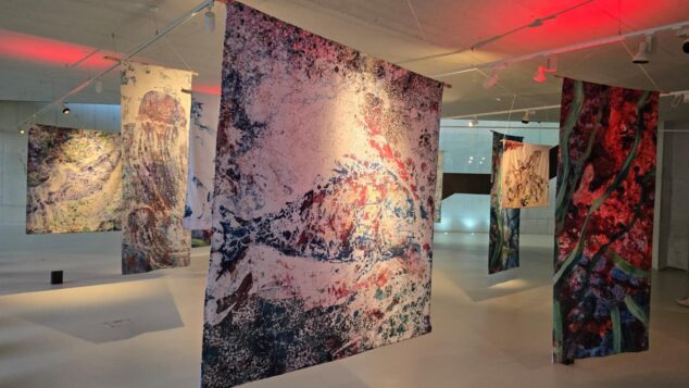 «Arrels Mediterrànies» abre Alere/Dolia 2026 con el arte de Ximo Canet como puente entre el mar y la tierra 9 Vista de varias obras textiles colgantes con motivos marinos y abstractos en una sala de exposiciones del Auditori Teulada Moraira.