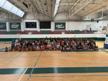 Gran grupo de niños y monitores posando en el pabellón deportivo municipal de Calp.